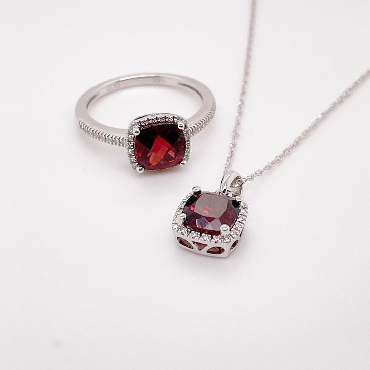 This deep red cushion-cut garnet is breathtaking and set beautifully within a diamond halo. This necklace was designed with a matching ring as shown in the pictures. These two make a stunning set that is the perfect addition to any jewelry collection. The necklace looks great on any woman as it will match their lipstick and lips! The details for this beautiful necklace are listed below:Metal Quality: 14K White GoldPendant Style: Garnet Diamond HaloDiamond Number: 20Diamond Shape: Round Brilliant Dazzling Ruby Jewelry For Gifts, Luxury Ruby Jewelry With Halo Design, Elegant Cushion Cut Cubic Zirconia Jewelry, Formal Jewelry With Square Diamond Pendant, Cushion Cut Ruby Jewelry As Gift, Formal Jewelry With Diamond Accents And Square Pendant, Cushion Cut Ruby Jewelry For Gift, Cushion Cut Ruby Jewelry Gift, Formal Square Pendant Jewelry With Diamond Accents