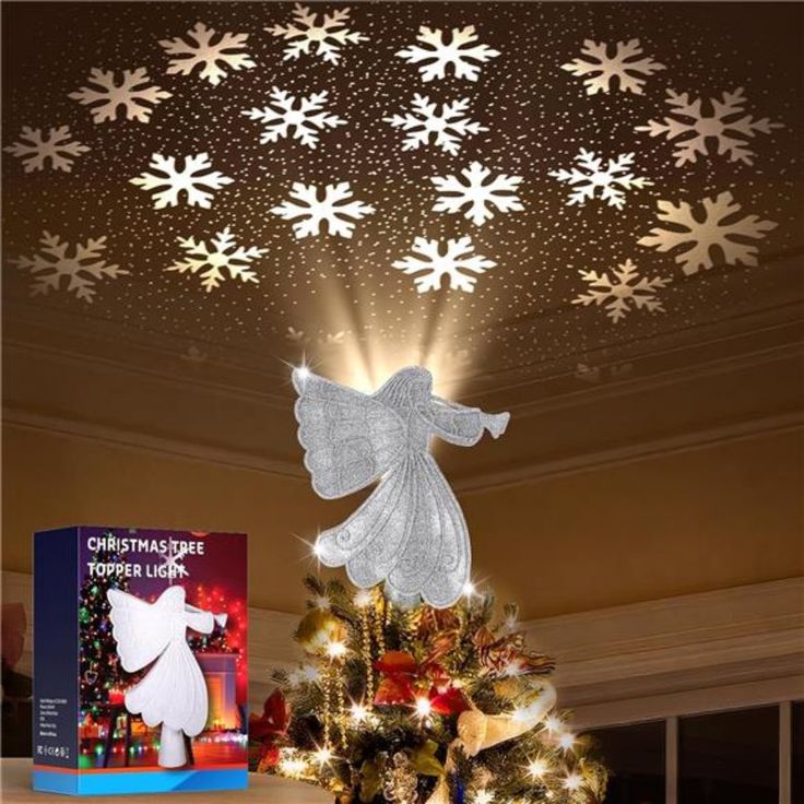 a christmas tree with snowflakes hanging from it's ceiling and an angel on top