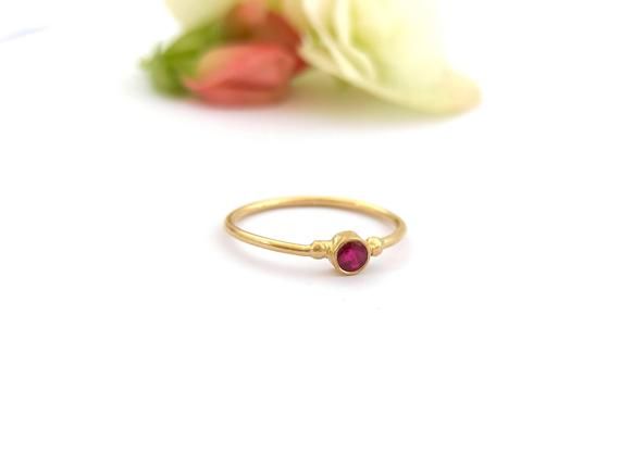 Minimalist solitaire 14k yellow, white, or rose gold ring with a beautiful round natural Ruby, dainty stacked solid gold ring. This dainty 14K yellow gold ring has a tiny round Ruby in the center, with two little gold dots at each side. This ring is delicate and comfortable to wear and will be great for everyday use, as for a special occasion. You can wear it on its own as a minimalist ring or stacked with other rings of deferent color or texture. This ring can also be a great modern engagement Minimalist Ruby Birthstone Ring, Minimalist Ruby Ring Birthstone, Dainty Round Cut Ruby Ring, Minimalist Ruby Ring With Birthstone, Dainty Ruby Ring In Yellow Gold, Minimalist Gold Solitaire Ruby Ring, Minimalist Yellow Gold Ruby Ring For Formal Occasion, Minimalist Gold Ruby Ring With Bezel Setting, Minimalist Yellow Gold Ruby Birthstone Ring