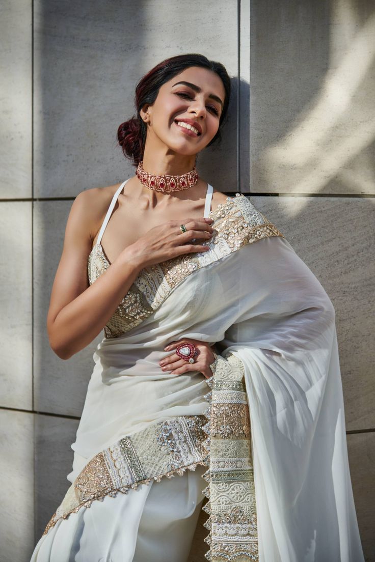 Editor's Note Featuring an ivory georgette saree enhanced with gold multi patch embroidered border, paired with a silk bralette. Fabric: Sari: georgette, bralette: dupion silk Color: Ivory, gold Component: Sari and bralette Sleeve type: sleeveless Neckline: Sweetheart Occasion: Festive Care: Dry Clean Only About the Designer Varun’s work marries the beauty of heritage Indian handcrafted embroideries with a modern colour sensibility. His clothes range from traditional saris and lehenga ensembles Mint Saree, Guru Dutt, Varun Bahl, Cotton Sarees Handloom, Silk Bralette, Zardozi Embroidery, Brocade Blouses, White Saree, Embroidered Saree