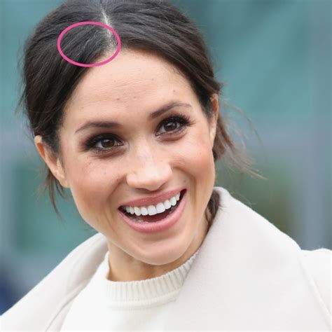 a close up of a person wearing a white coat with a pink ring on her head