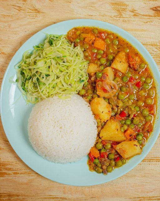 the meal is prepared and ready to be eaten on the table, including rice, beans, and vegetables