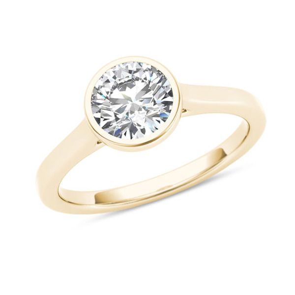 a yellow gold ring with a round cut diamond in the center, on a white background