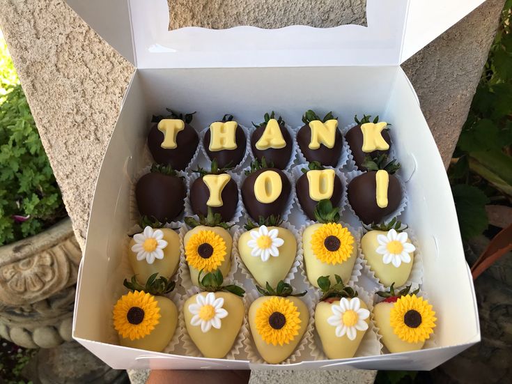 a box filled with chocolate covered strawberries and sunflowers that say thank you