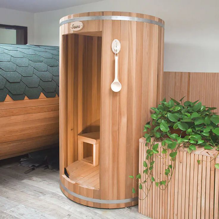 a wooden sauna next to a potted plant