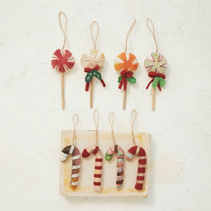 four christmas candy lollipops are hanging on the wall