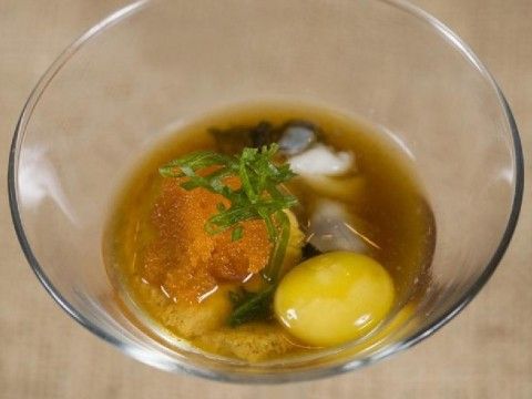 a glass bowl filled with soup and vegetables