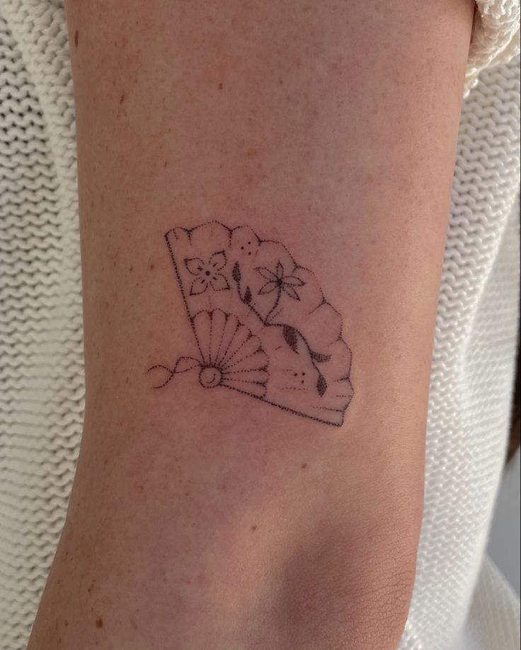 a woman's arm with a small tattoo design on the left side of her body