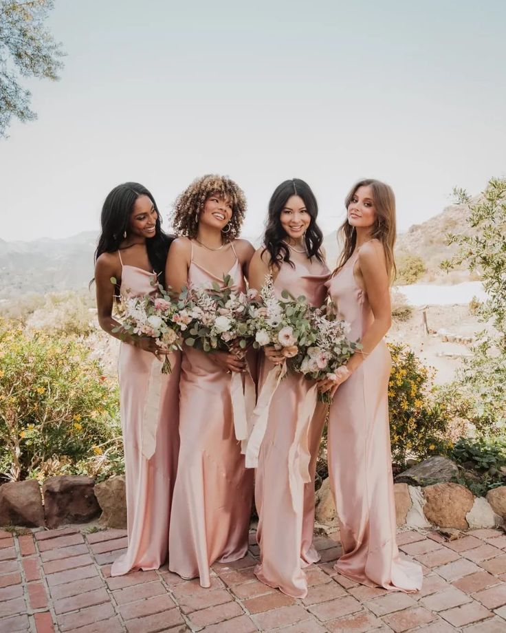 the bridesmaids are all wearing pink dresses and holding bouquets in their hands