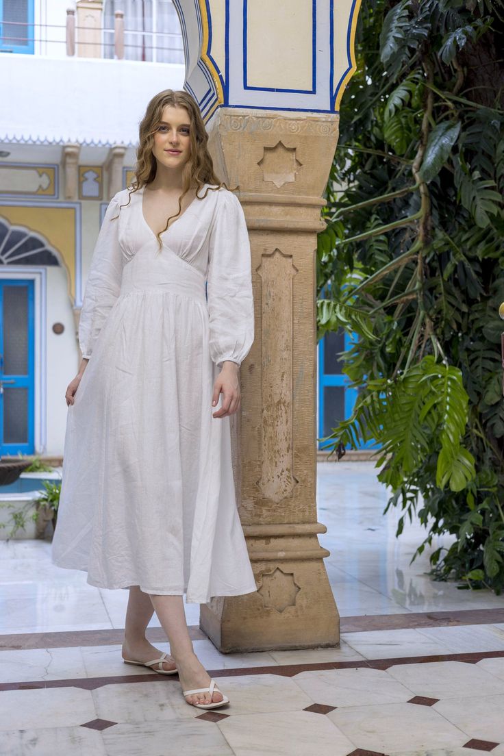 "▶ ABOUT THE DRESS: This white linen midi dress is a beautiful and ethereal dress with a deep V neckline which can be made higher as well, long sleeve with elastic cuff. Perfect for a day out as well as a late evening dress. Made from 100% linen fabric and comes fully lined, the dress has a relaxed fit and we offer it in plus sizes up to 4XL. ▶ ITEM DETAILS: * Long Midi dress, made with 100% organic linen and fully lined. * The model is 5'10 tall and wearing size S. * Handmade item, crafted to perfection. * The length of the dress is 48\" or 122cm and can be made longer or shorter.  * The length of the sleeve is 20\" or 51cm and can be made longer or shorter.  * The dress comes with an elastic band and zipper closure at the back. ▶ SIZE GUIDE (DRESS MEASUREMENTS): SIZE XS /US 0-4 Bust: 34. Linen V-neck Wedding Dress, White Maxi Dress With Fitted Bodice For Daywear, Elegant Linen Maxi Dress With Fitted Bodice, Fitted White Linen Midi Dress, White Fitted Linen Midi Dress, Elegant White Linen Maxi Dress, Fitted Linen Maxi Dress For Wedding, Fitted White Linen Wedding Dress, Linen Midi Length Dress For Wedding