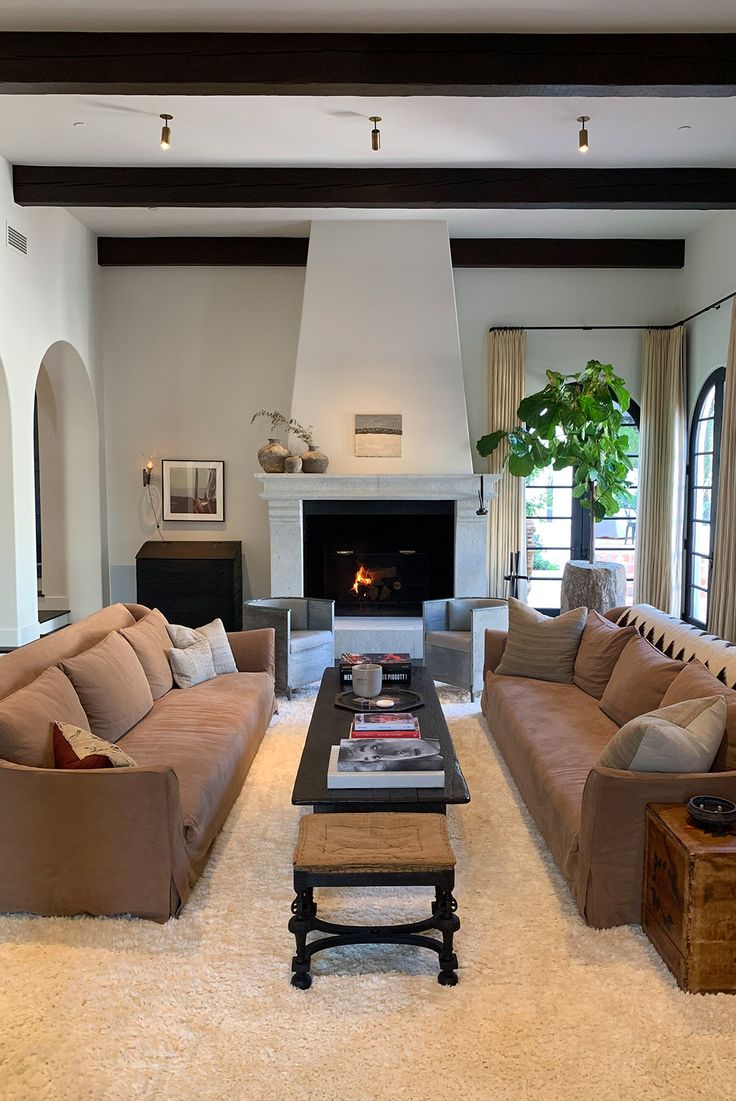 a living room filled with furniture and a fire place in the middle of a room