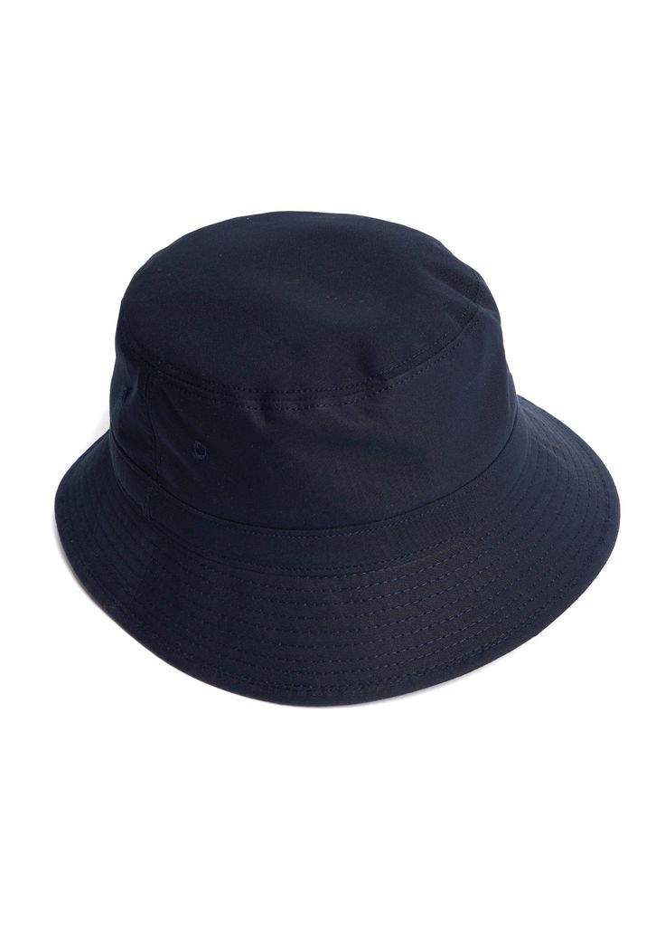 A classic bucket hat made from 100% cotton Ventile, the same fabric used on our namesake trench coats. This hat will repel the wind and the water and block the sun from your eyes but also BREATHE. It's the perfect choice for warm weather adventures! Currently available in khaki and navy. THE DETAILS: Wind and water repellant and very breathable Minimal external branding Care: brush clean with a damp cloth Ventile fabric is woven in Switzerland from American grown and spun extra long staple (ESL)