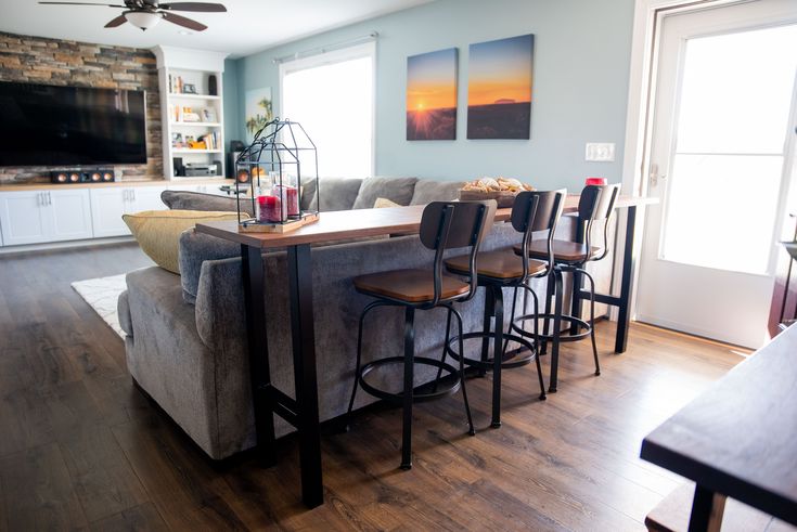 a living room filled with furniture and a flat screen tv mounted to the side of a wall