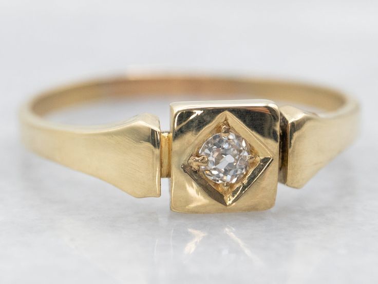 a yellow gold ring with a diamond in the center