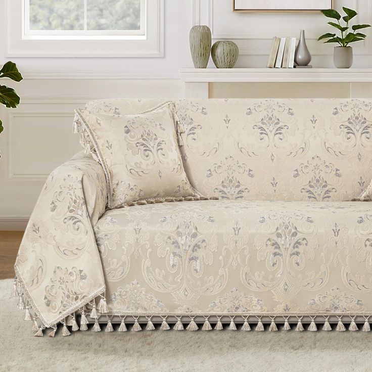 a living room with a couch and some potted plants on the side table in front of it