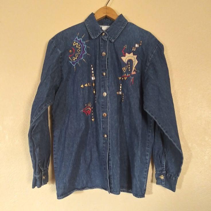 "Vintage INFO USA Aztec Studded Denim Button Down Shirt Women's Medium Pit to pit 21\" Length 27\" Make a statement with this vintage Aztec studded denim button-down shirt. The long-sleeved shirt is made of cotton fabric that feels soft and comfortable against the skin. The shirt is perfect for casual outings and gives off a basic style that can be dressed up with accessories. It features a collared neckline and a button closure that adds a subtle but stylish touch. The shirt comes in a beautiful blue color that can complement any skin tone. This women's medium-sized shirt is ideal for those who love to express themselves through fashion." Vintage Medium Wash Denim Top For Fall, Vintage Button-up Denim Top, Vintage Collared Denim Top In Medium Wash, Vintage Collared Medium Wash Denim Top, Vintage Long Sleeve Denim Top For Fall, Vintage Medium Wash Button-up Denim Top, Vintage Medium Wash Denim Button-up Top, Vintage Long Sleeve Denim Top With Button Closure, Vintage Blue Button-up Denim Top