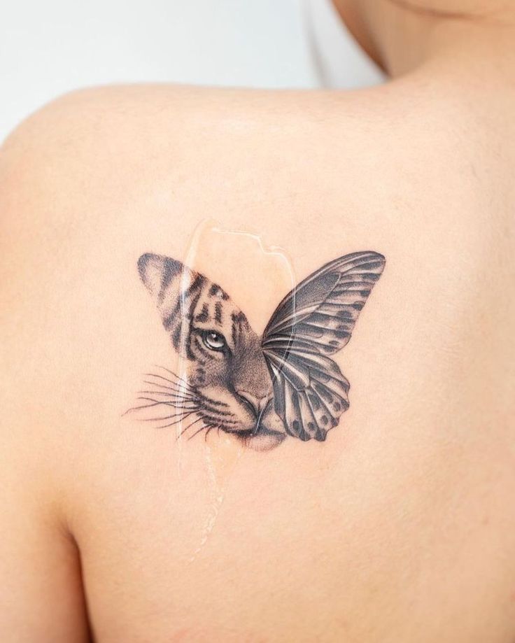 a close up of a person with a tattoo on their shoulder and a tiger head