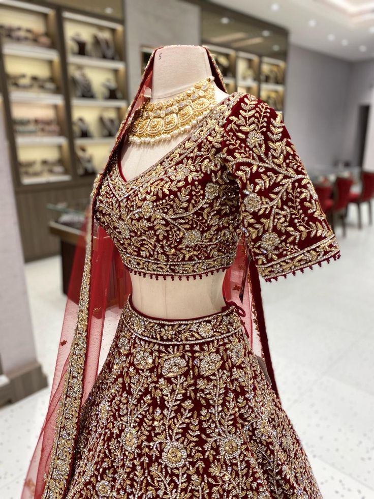 "Go for the bold and take on the challenge with our Maroon Bridal Lehenga BL-150! Featuring intricate silver stone and gold work detailing on a rich velvet fabric, this lehenga is destined to make you stand out on your special day. Embark on a unique and adventurous bridal journey with this stunning piece!" Fabric: Velvet! WASH CARE INSTRUCTIONS - Please Dry clean only when it is applicable! Ready to Ship! Ceremonial Kundan Choli With Intricate Embroidery, Elegant Velvet Lehenga For Festive Occasions, Festive Traditional Wear With Stone Work In Traditional Drape, Festive Traditional Wear With Stone Work And Traditional Drape, Elegant Festive Velvet Lehenga, Red Velvet Choli With Intricate Embroidery, Traditional Red Velvet Sharara, Elegant Velvet Choli For Wedding, Red Velvet Sharara For Wedding