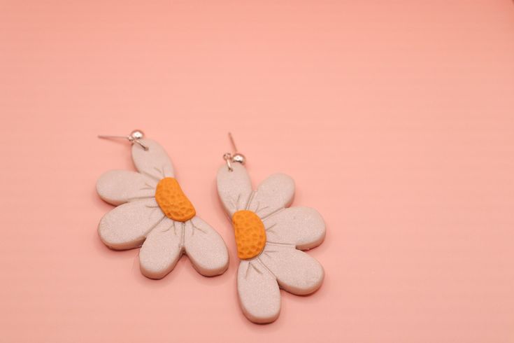 Half Daisy polymer clay earrings, available in white and orange.   ---------------------------------- Please note each item is handmade and therefore may differ slightly from the pictures.  To clean your clay earrings simply wipe with a damp cloth. To get the longest life out of your earrings we suggest removing them before swimming, showering, sleeping or apply product to your face and hair. Cute Hand Painted White Jewelry, Cute White Hand Painted Jewelry, White Hand Painted Polymer Clay Earrings, Hand Painted White Polymer Clay Earrings, Hand Painted White Clay Jewelry, White Clay Earrings For Gift, White Clay Earrings For Gifts, White Clay Earrings As Gift, Nickel-free White Clay Jewelry