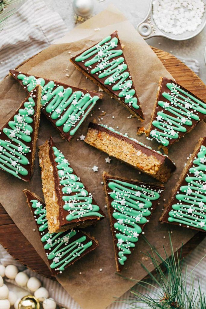 cookies decorated with green icing and sprinkles on a wooden cutting board