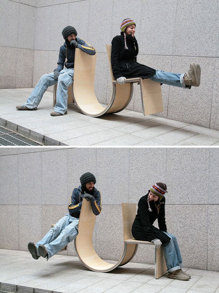 two men sitting on benches made out of cardboard