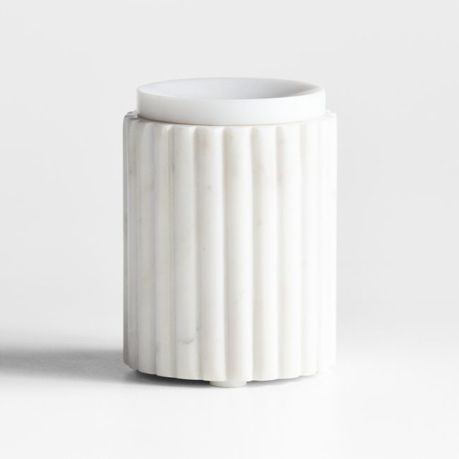 a white vase sitting on top of a table