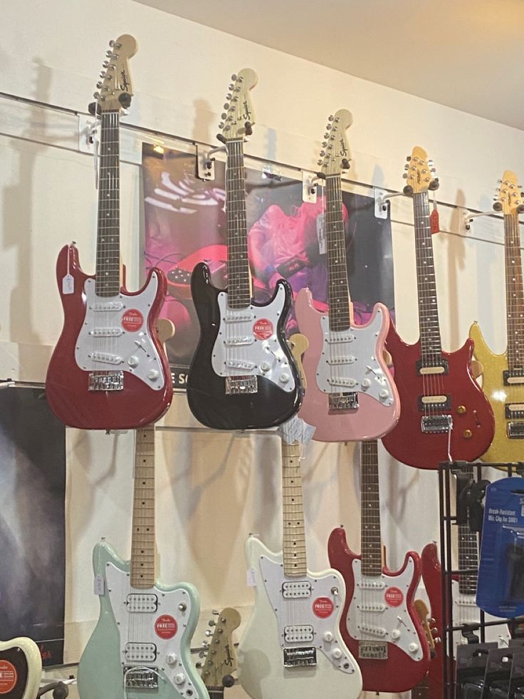 guitars are lined up on display in a music store