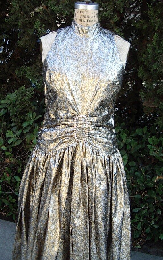 "Oscar Night Gown. Vintage 1980s Designer Original Gown made of rare 1960s French Gold & Silver Metallic Brocade.  The fabric is softly draped through a large AB Rhinestone Buckle at the hips, a fitted Halter Top Bodice that is open to the waist in back and could be split in the center front to reveal the breast which is so important at the Awards Shows.  A Band Collar with Stone Buttons in back and the buttons are repeated at the center  back hip drape.  The Full Skirt has a front opening at th Vintage Fitted Evening Gown, Gold Vintage Evening Dress, Vintage Fitted Gown For Evening Dress, Vintage Gold Dress For Evening, Vintage Fitted Gown For Formal Occasions, Vintage Fitted Gown For Evening, Vintage Fitted Gown For Evening Occasions, Vintage Evening Dress For Prom Season, Vintage Evening Gown For Prom Season