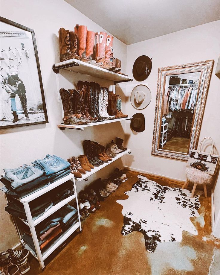 a mud floor in a room with shoes and hats on the shelves next to a mirror