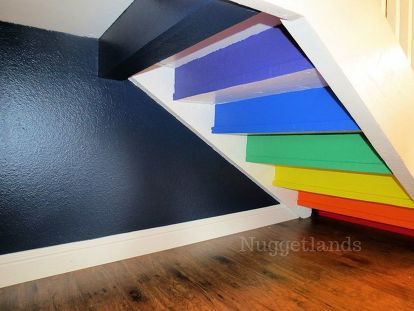 there are many different colors of paint on the wall and under the stair case in this room