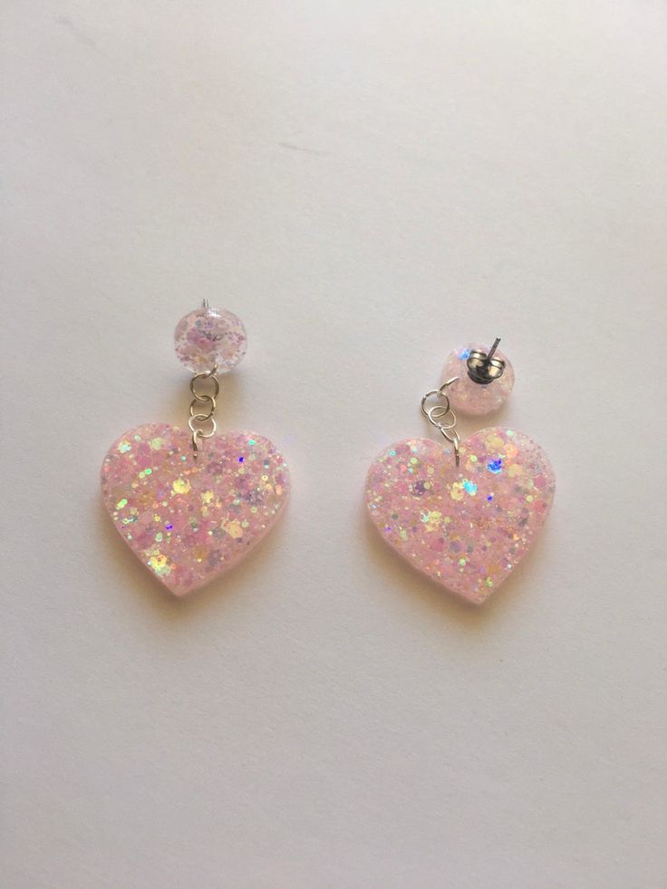 two pink heart shaped earrings with white and light pink sparkles on the ear wires