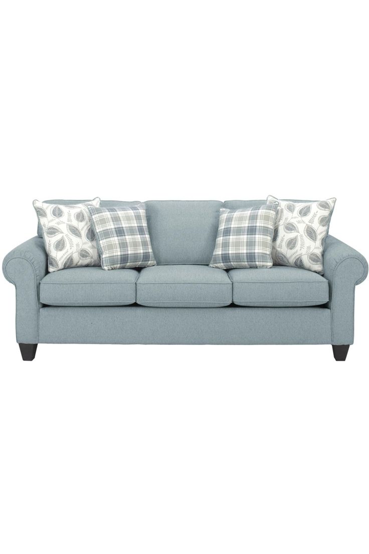 a blue couch with plaid pillows on it and two throw pillows in front of the couch