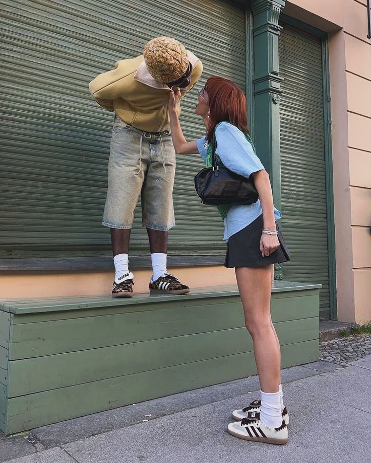 a woman standing next to a man on top of a step in front of a building