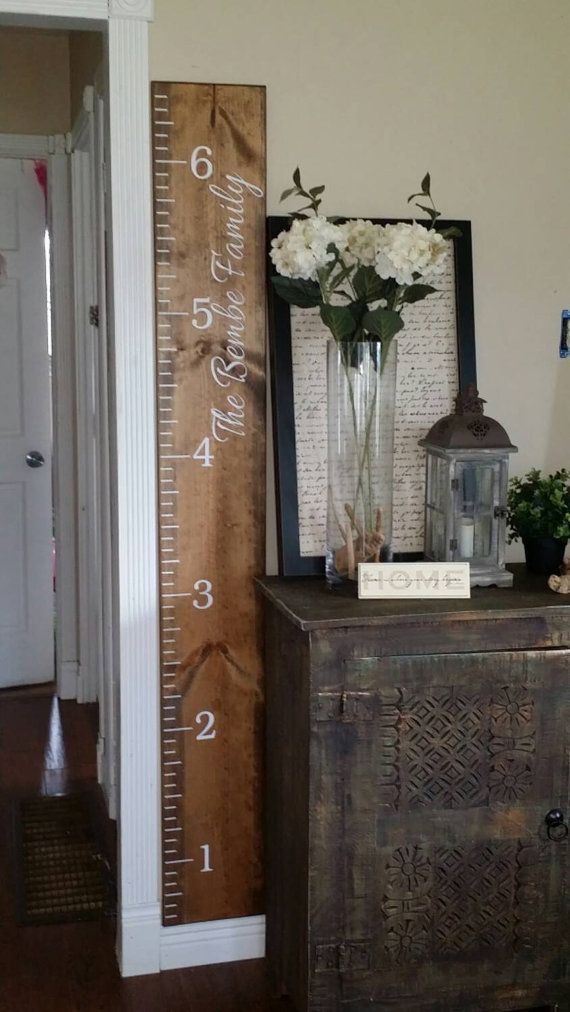 a tall wooden ruler is next to a vase with flowers