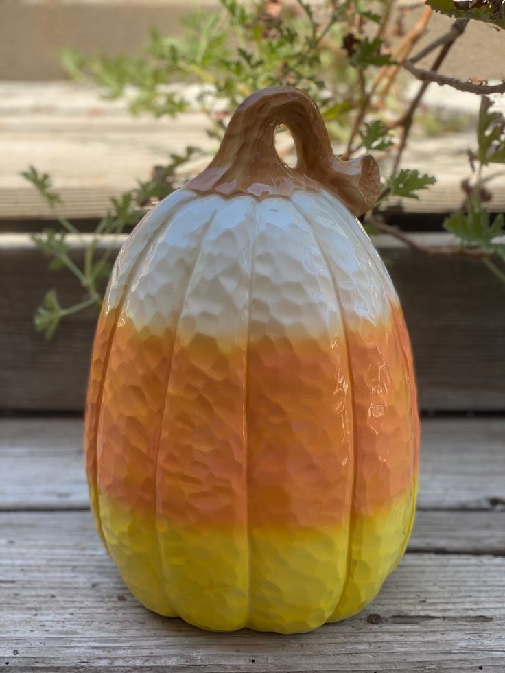 a ceramic pumpkin sitting on top of a wooden table