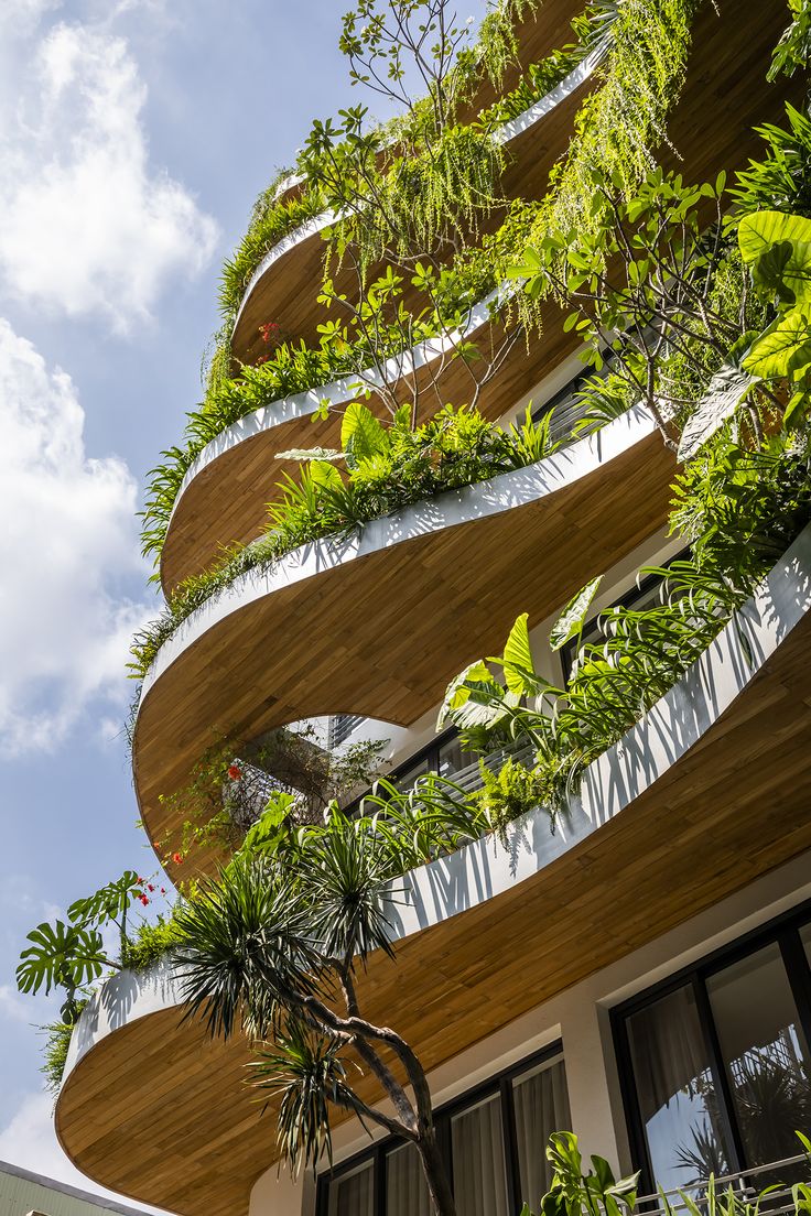 an unusual building with plants growing on the side and balconies in the front