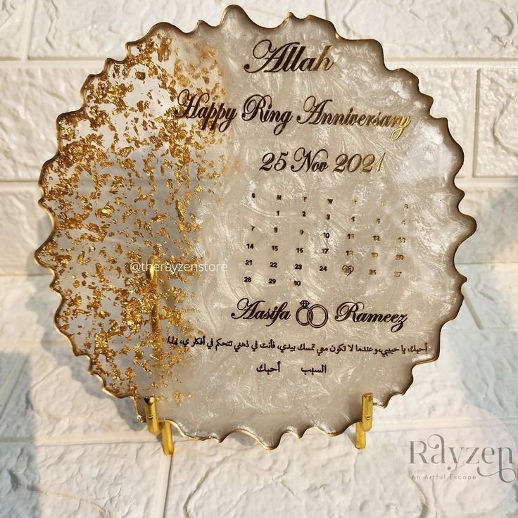 a white and gold wedding anniversary plaque on a brick wall in front of a tile background