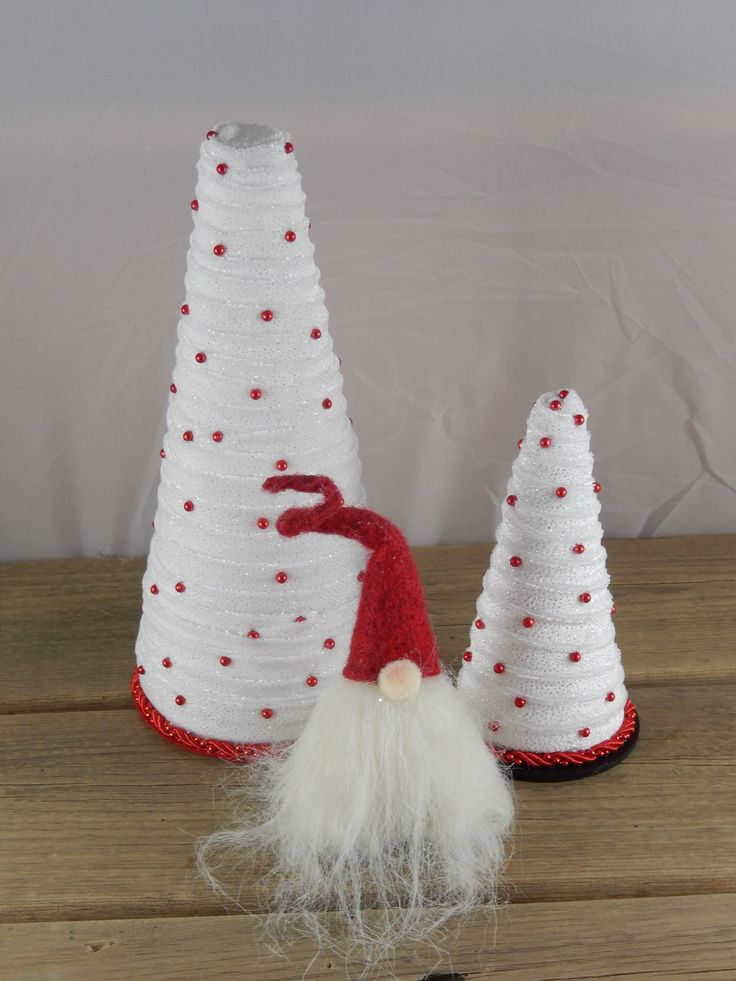 two knitted christmas trees with white and red hats