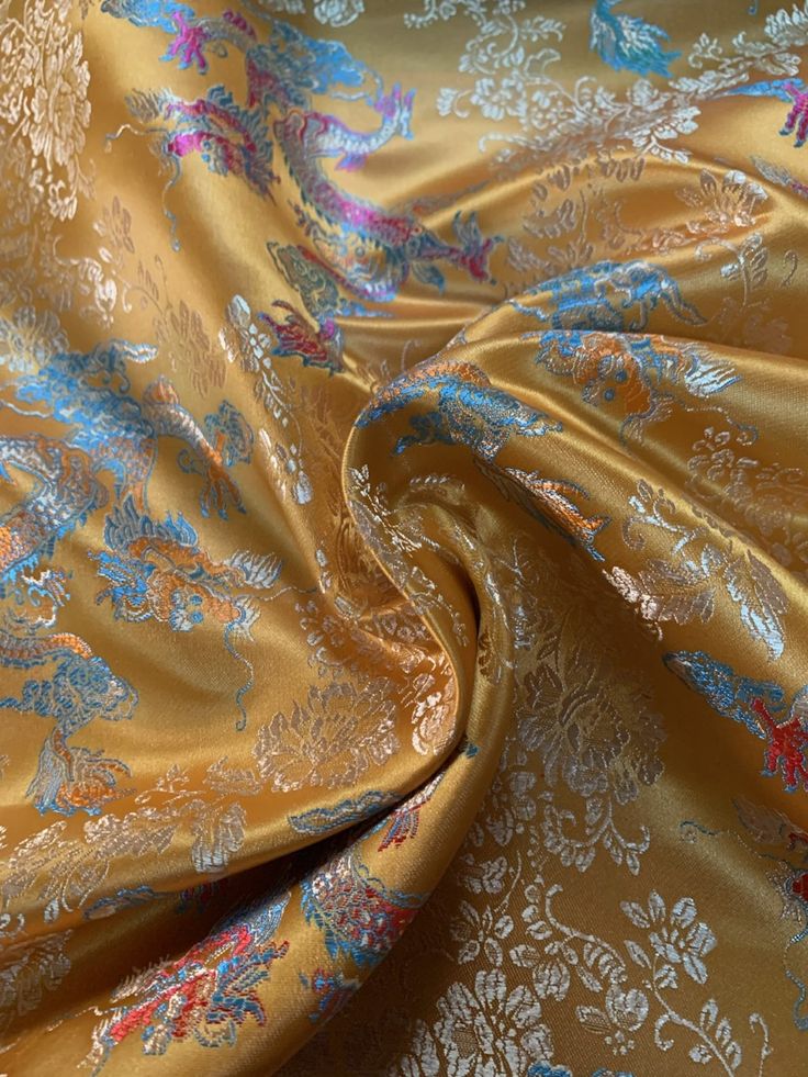 an image of a gold and blue flowered fabric with metallic foil on the bottom