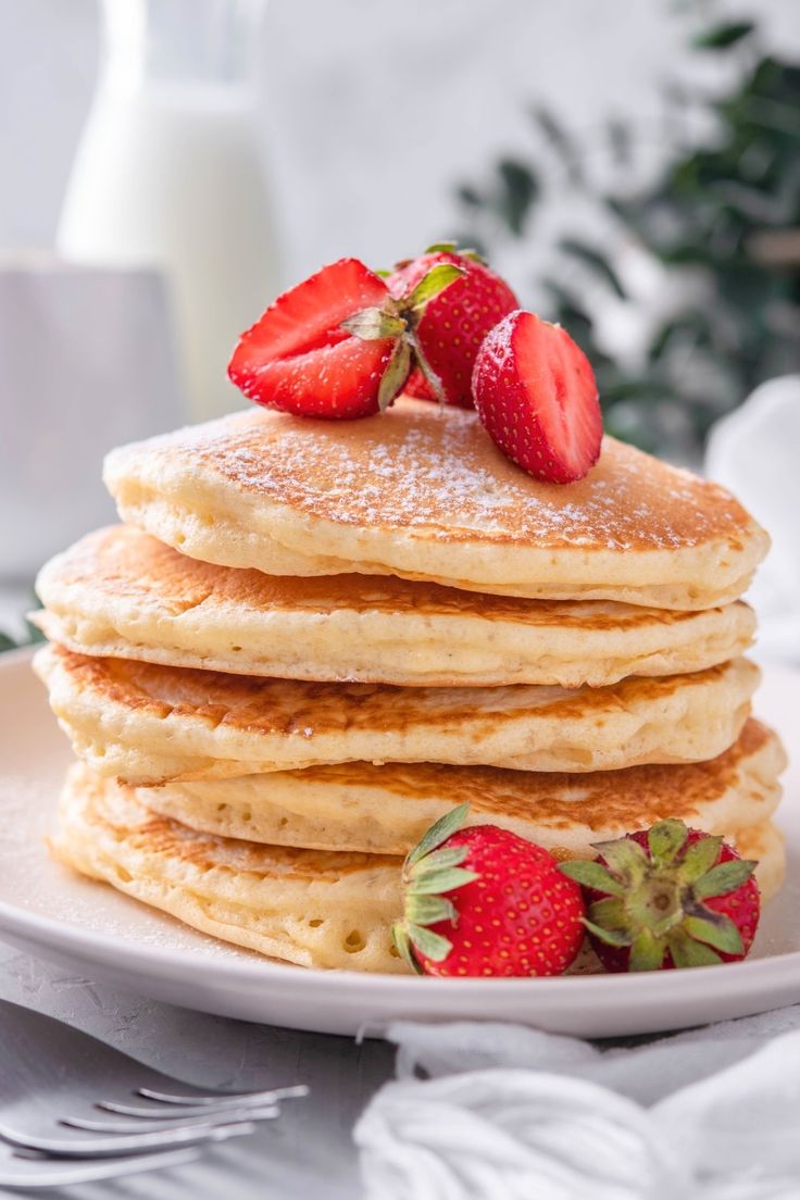 a stack of pancakes with strawberries on top