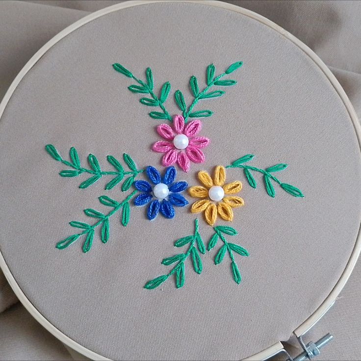 an embroidery project with flowers and leaves on it