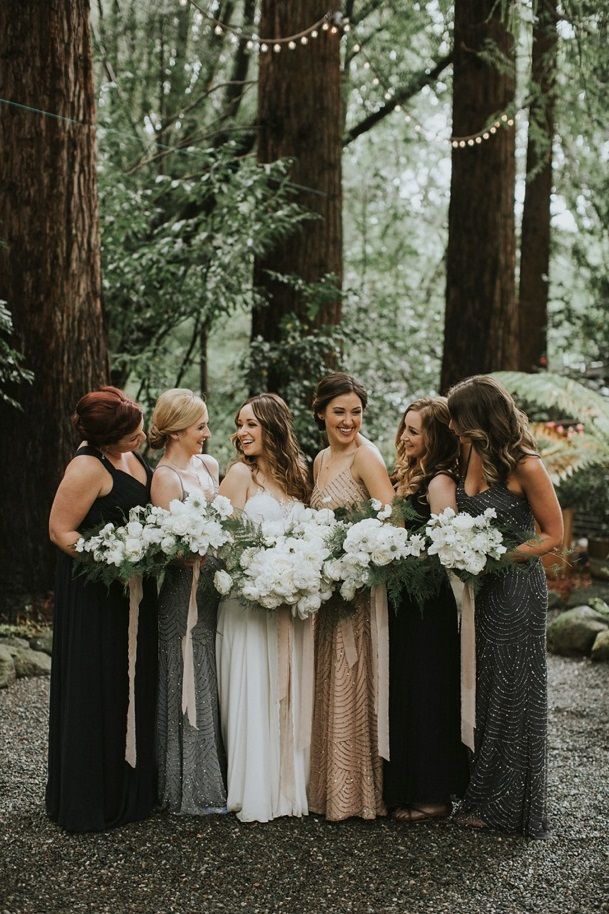 a group of women standing next to each other in front of trees