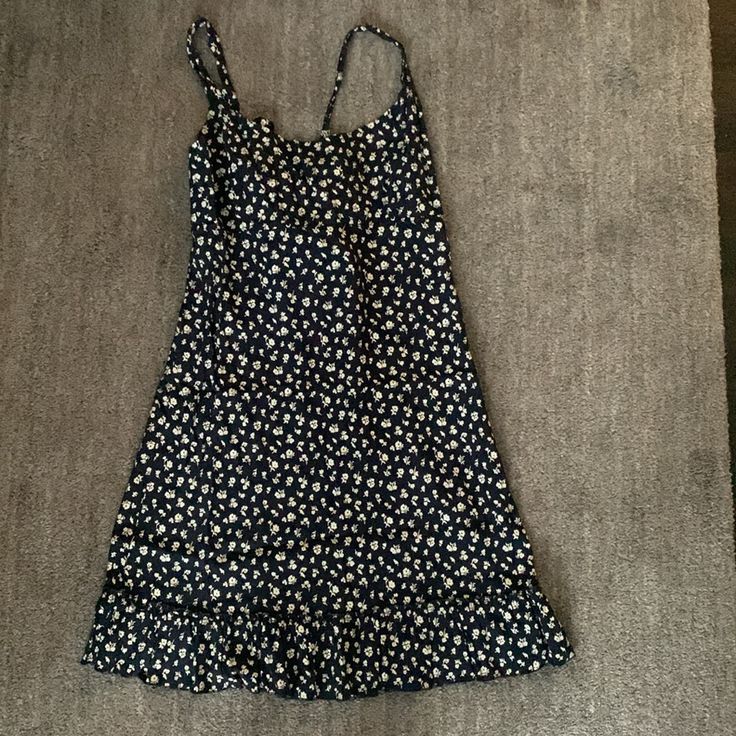 Brandy Melville Colleen Dress. Never Worn. One Size. Dark Navy With Ivory Ditsy Floral Print. Tie Detail At Back. Ruffle Trim At Hem. Chest: 17” Across. Length: 34 1/2” From Top Of Shoulder Strap Can Be Pulled In Tighter With Tie At Back. Casual Mini Sundress With Ruffle Hem, Casual Cotton Daisy Print Dress, Casual Floral Dress With Ruffle Hem For Daywear, Sleeveless Mini Dress With Daisy Print, Daisy Print Sundress For Day Out, Beach Mini Dress With Daisy Print, Cute Cotton Mini Dress With Ditsy Floral Print, Sleeveless Daisy Print Mini Dress, Casual Ditsy Floral Print Midi Dress