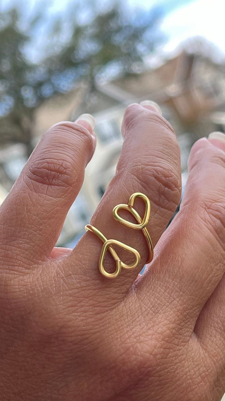 a person's hand with a gold ring on their finger and the word love written in cursive letters