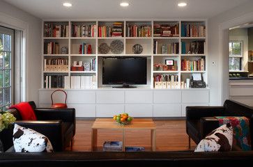 a living room filled with furniture and a flat screen tv mounted on a wall above a fire place