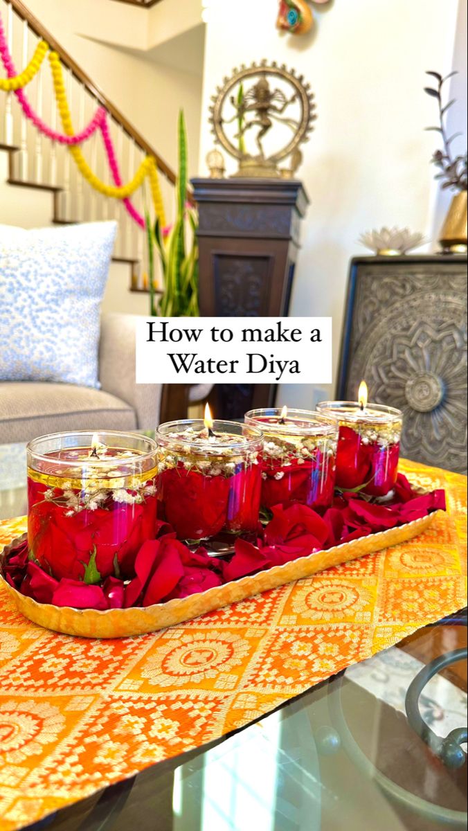 some candles are sitting on a tray with red flowers in it and the words how to make a water diya