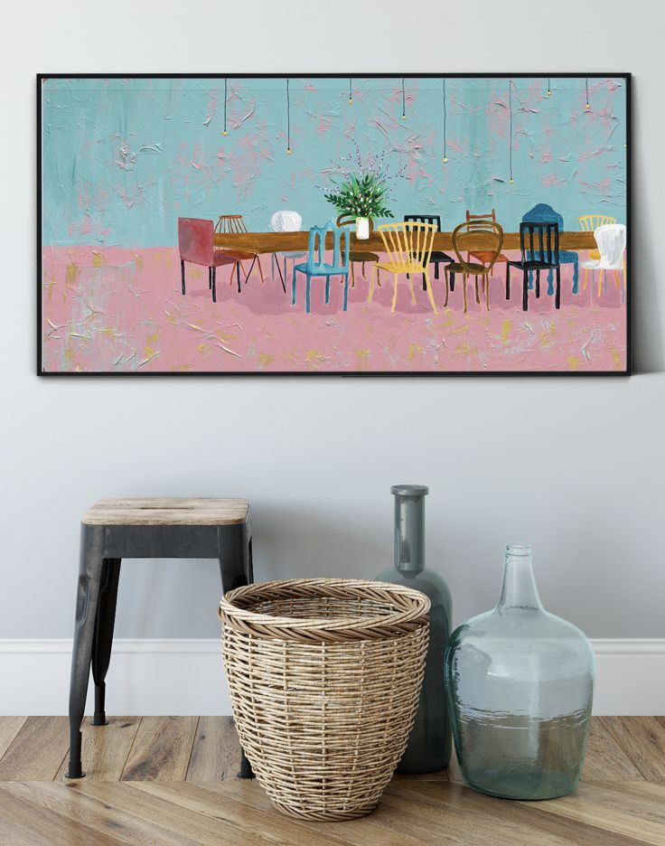 a painting hanging on the wall next to a basket and vase