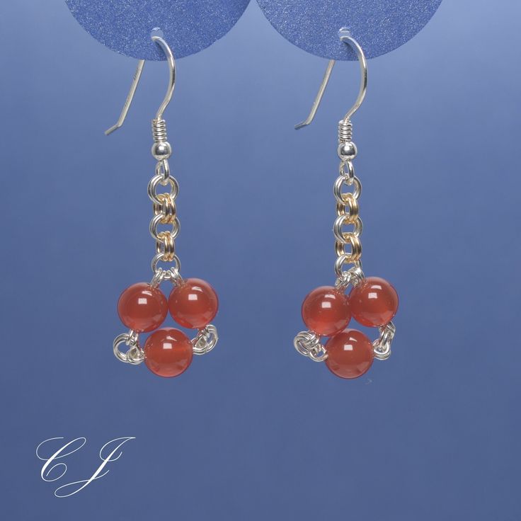 "I handmade these red carnelian earrings just for you. They are round gemstone beads, but they are arranged to resemble little red hearts. These cute little earrings will make a delightful addition to your Summer and Fall accessory collection. Ancient Byzantine and Assyrian cultures used Carnelian to foster courage, and so can you. Silver and gold filled jump rings provide a subtle contrast.  Please note: Gemstone beads are natural and therefore have slight variations in texture and color. The b Red Carnelian Round Bead Jewelry, Round Beaded Earrings With Natural Stones As Gift, Round Natural Stones Beaded Earrings As Gift, Red Round Agate Jewelry, Red Jewelry With Carnelian Gemstones, Red Jewelry With Gemstone Carnelian, Red Carnelian Gemstone Jewelry, Red Wire Wrapped Drop Earrings, Red Wire Wrapped Dangle Earrings