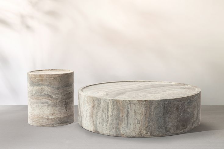 two marbled objects sitting next to each other on a gray tableclothed surface