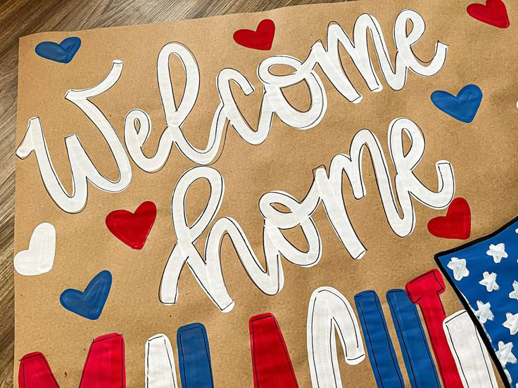 a welcome home sign with red, white and blue decorations